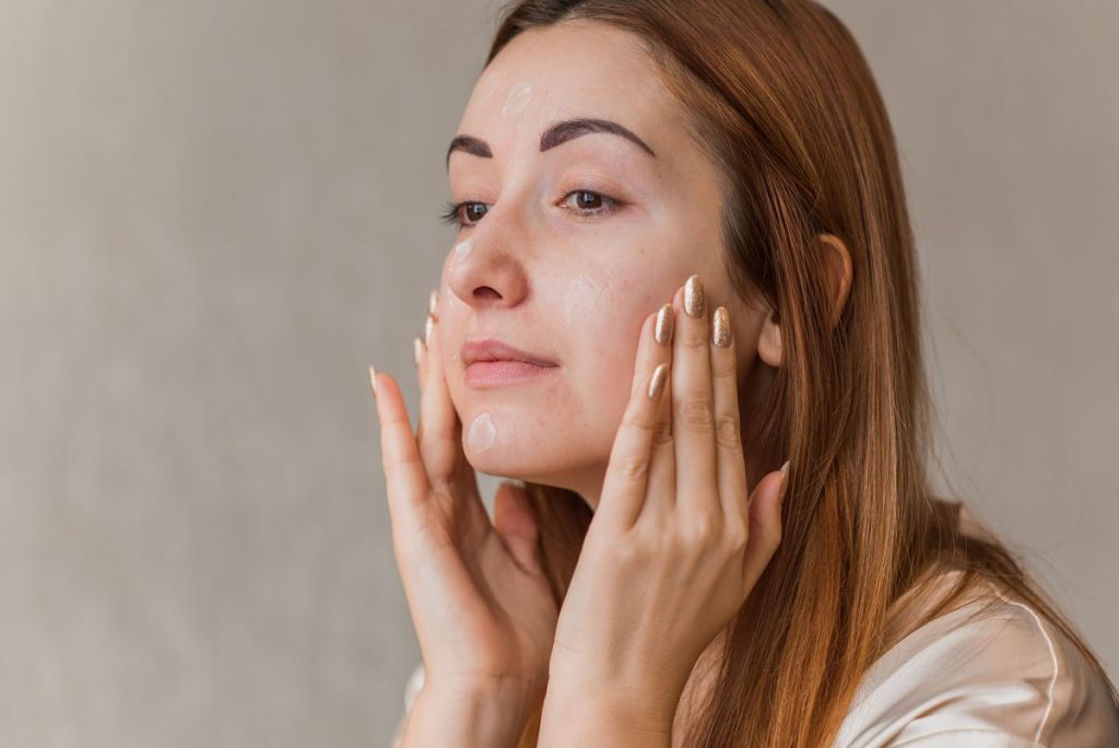 Woman applying lotion to her face