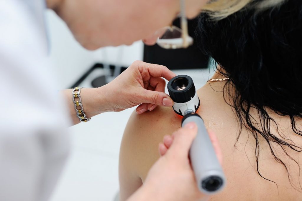 Dermatologist using a dermatoscope on a patient