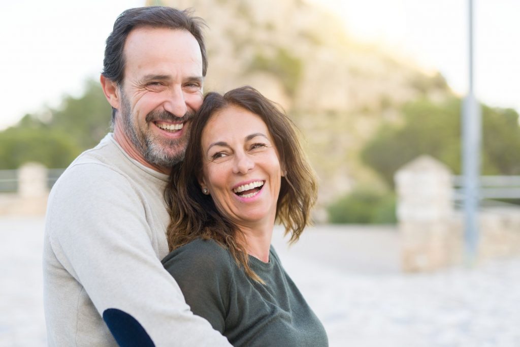 Romantic couple smiling, cuddling and hugging on a sunny day